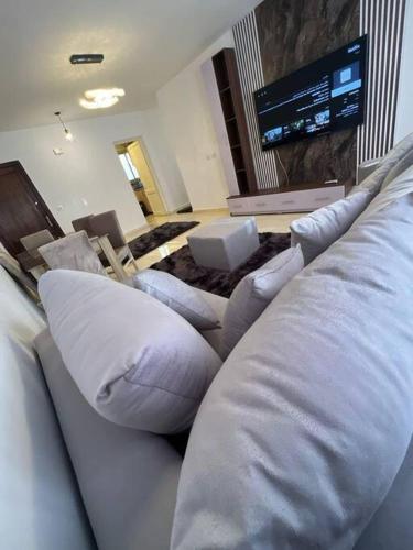salon z kanapą i telewizorem w obiekcie Cozy master bedroom With A/C w mieście Madinaty