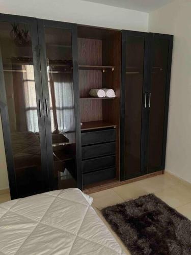 sypialnia z drewnianymi szafkami i łóżkiem z dywanem w obiekcie Cozy master bedroom With A/C w mieście Madinaty