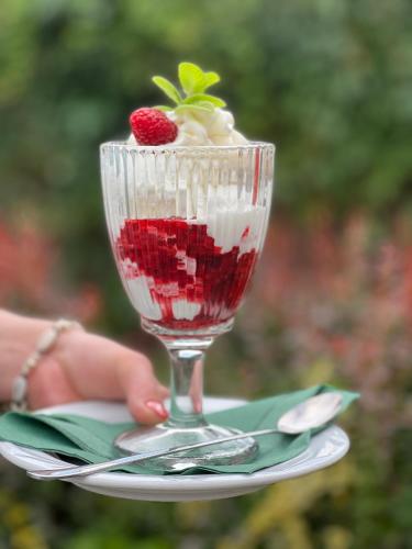 a glass cup with a strawberry in it on a plate at Hotel i Restauracja Castle in Bystrzyca Kłodzka