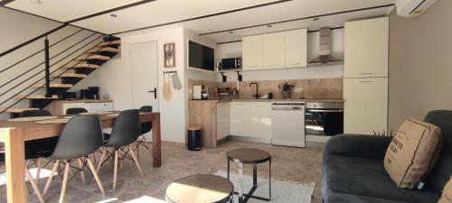 a kitchen and living room with a table and chairs at La maisonnette "Au calme et sans vis à vis" in Canaules-et-Argentières