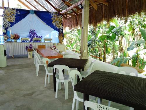 um restaurante com mesas e cadeiras e uma tenda em Isla Haruhay em Dapa