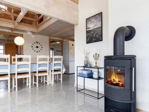 - un salon avec une cheminée et une salle à manger dans l'établissement Holiday home Løkken CXLVII, à Løkken