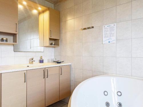 La salle de bains est pourvue d'une baignoire et d'un lavabo. dans l'établissement Holiday home Løkken CXLVII, à Løkken