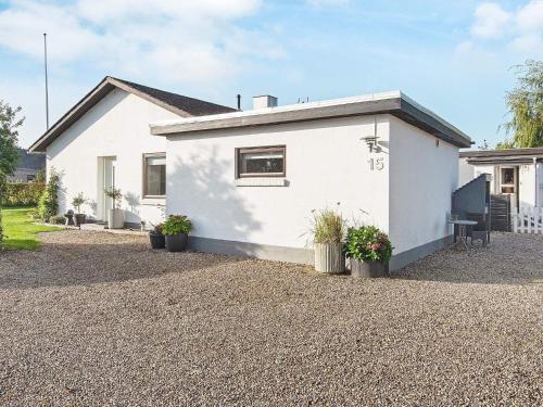 a white house with potted plants in front of it at 4 person holiday home in Haderslev in Haderslev