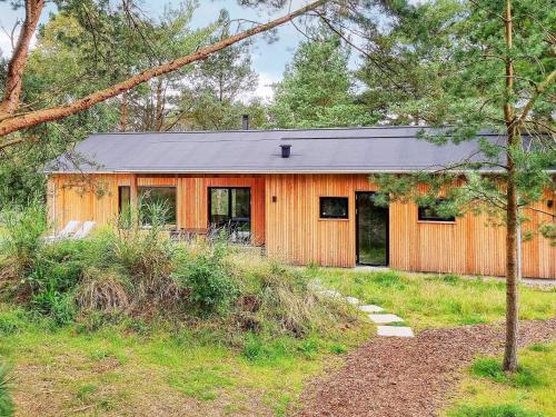 une maison en bois avec un toit noir dans l'établissement 8 person holiday home in lb k, à Ålbæk
