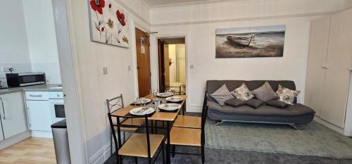 ein Wohnzimmer mit einem Sofa und einem kleinen Tisch in der Unterkunft Lawnswood Apartments in Blackpool