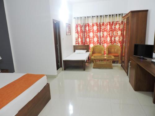 Habitación de hotel con cama y TV en Hotel Travellers Nest Kandy, en Kandy