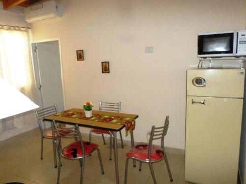 a kitchen with a table with chairs and a refrigerator at Departamento confortable en Guaymallén in Guaymallen