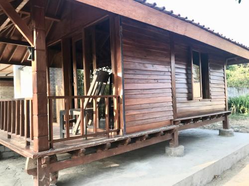 a small wooden house with a window on a porch at Muni's Lombok Bungalow in Masbagik