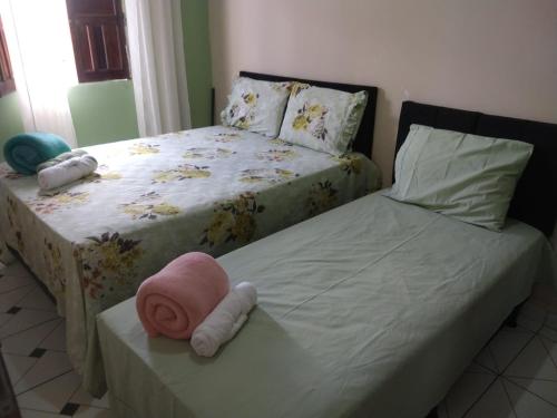 穆庫熱的住宿－Aluga-se uma casa em Mucugê Bahia，一间卧室配有两张床,一张桌子上挂着粉红色的帽子