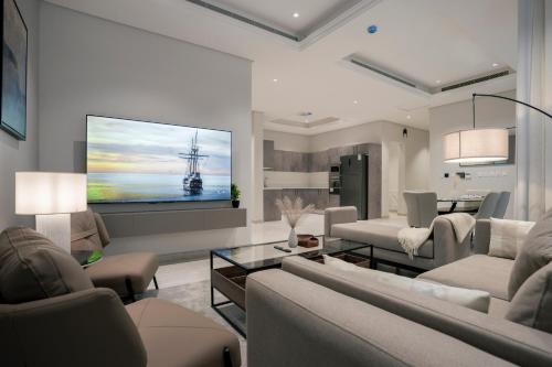 a living room with couches and a large screen tv at Golden Yasmin in Riyadh