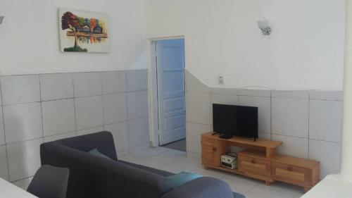 a living room with a couch and a tv at Studio Mpita in Pointe-Noire