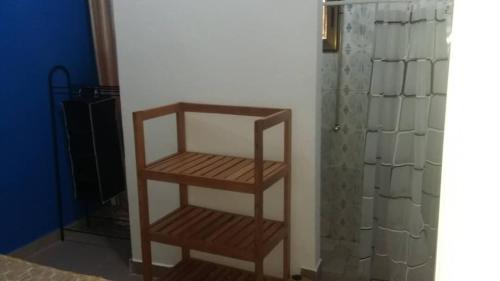 a wooden shelf in a room next to a shower at Studio Mpita in Pointe-Noire