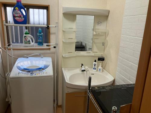 a small bathroom with a sink and a mirror at 4 Bedrooms, 3 Toilets, 2 bathtubs, 2 car parking , 140 Square meter big Entire house close to Makuhari messe , Disneyland, Airports and Tokyo for 18 guests in Narashino