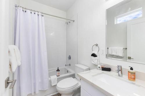 une salle de bain blanche avec toilettes et lavabo dans l'établissement Syrax's Dragonstone Den, à Seattle