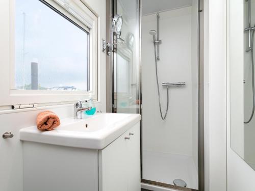 biała łazienka z umywalką i prysznicem w obiekcie La Serafat w mieście Maasbommel