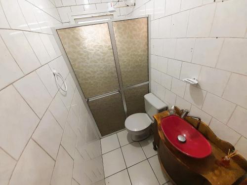 a bathroom with a red sink and a toilet at Central APTO Santa Cruz do Sul in Santa Cruz do Sul