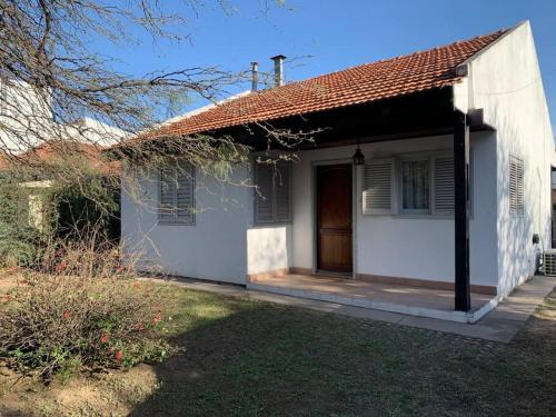 uma pequena casa branca com uma porta e um quintal em La casita de Isabella em Córdoba