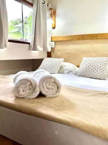 a bed with towels on top of it at Barlavento Villas Chalés e Suites in Ilhabela