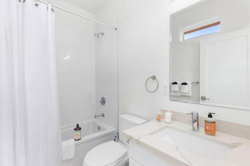 a white bathroom with a toilet and a sink at Vhagar's Valyria's Vista in Seattle