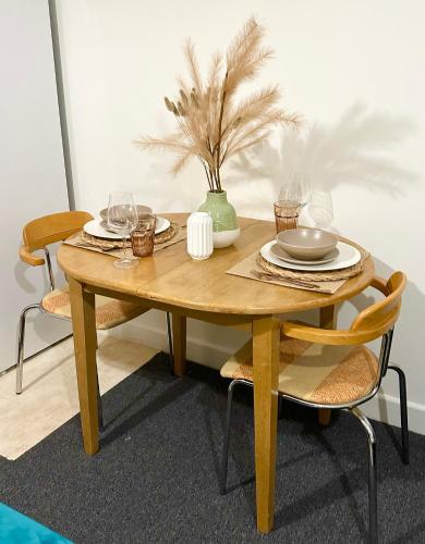 een houten tafel met borden en glazen erop bij Resting Place in Eastbourne