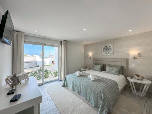 a bedroom with a bed and a large window at Luxury Villa Heated Pool, walk to São Rafael Beach, Albufeira in Albufeira