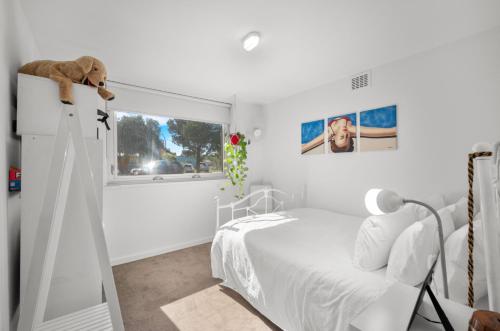 Un dormitorio blanco con una cama blanca y una ventana en A Larger Slice of Fremantle 3bed apt. Wifi-Netflix en Fremantle