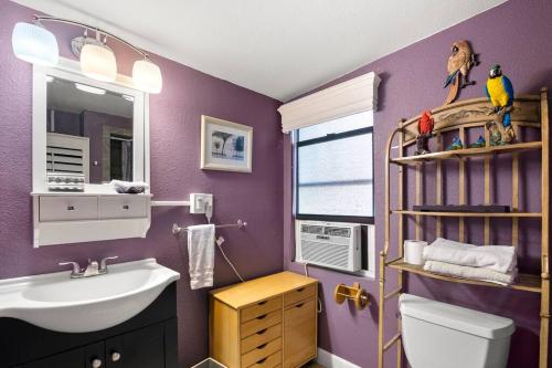uma casa de banho com um lavatório, um WC e um espelho. em Parrot Bay Retreat em Sarasota
