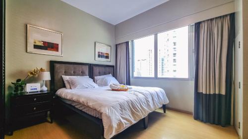 um quarto com uma cama e uma grande janela em Hotel like unit The Avant at the Fort em Manila