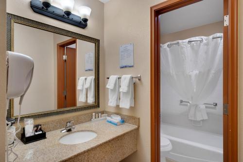 a bathroom with a sink and a toilet and a mirror at Clarion Inn in Sierra Vista