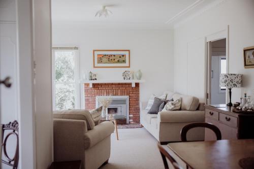 a living room with a couch and a fireplace at Ravenswood Farmhouse in Rylstone