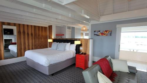 a bedroom with a bed and a couch in it at The Hotel at Cape Ann Marina in Gloucester