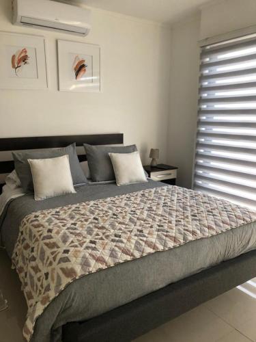 a large bed in a bedroom with a window at Departamento Los Canelos, a metros de Avenida Las Industrias- Incluye, NETFLIX DirecTV aire acondicionado, Internet in Los Ángeles