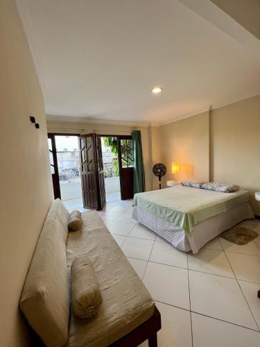 una camera con un letto e un divano di Residencial Ribeiro a Salvador