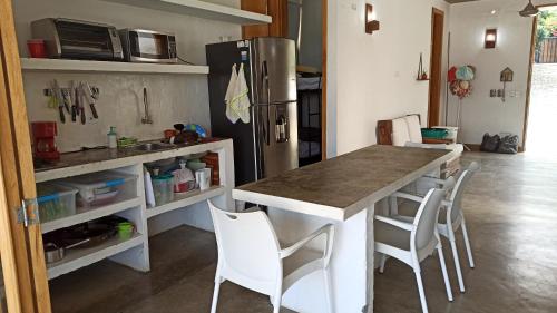 een keuken met een tafel en stoelen en een koelkast bij Casa de campo con piscina, en un clima ideal y un paisaje excepcional in Santa Fe de Antioquia