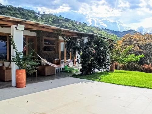een huis met een hangmat in de tuin bij Casa de campo con piscina, en un clima ideal y un paisaje excepcional in Santa Fe de Antioquia