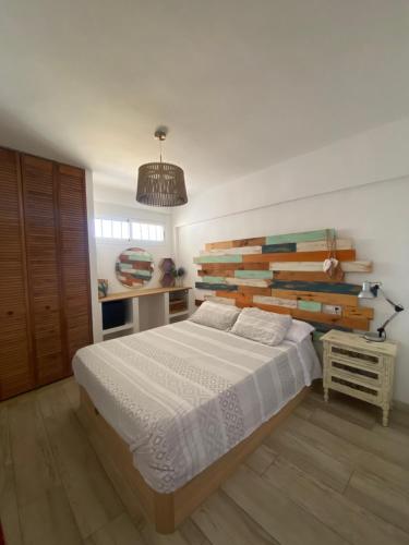 Schlafzimmer mit einem großen Bett mit einem Kopfteil aus Holz in der Unterkunft Bonito apartamento con vistas al mar in Las Negras