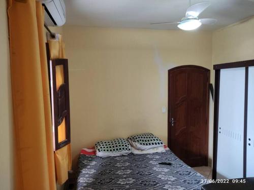 a small room with a bed and a door at Casa agradável com piscina a 200 metros da praia in Vila Velha