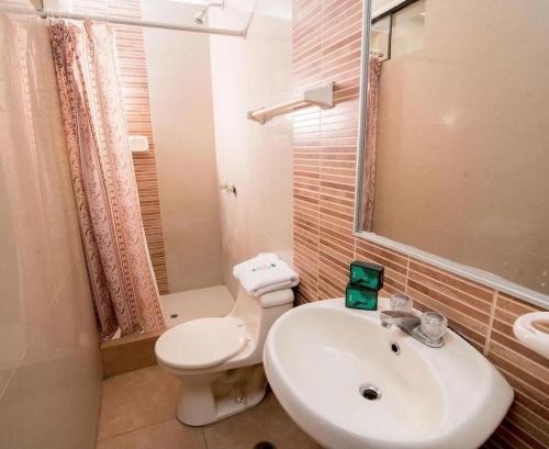 a bathroom with a white toilet and a sink at Hotel Arizona Piura in Piura