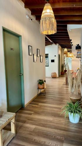a hallway with a green door and a wooden floor at Luum Casa Hotel Manila in Medellín