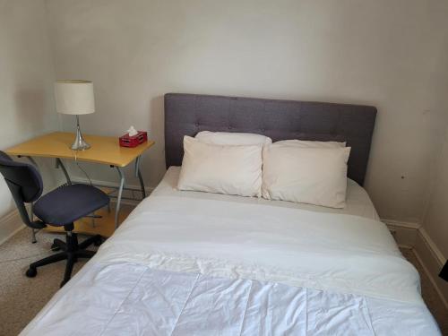 a bed with two pillows and a desk with a lamp at Cozy downtown two bedrooms free parking in Kingston