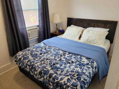 1 dormitorio con 1 cama con edredón azul y ventana en Cozy downtown two bedrooms free parking en Kingston