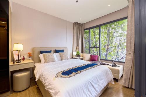a bedroom with a large bed and a large window at Once condo - Pattaya central location - Brand new apartments in Pattaya