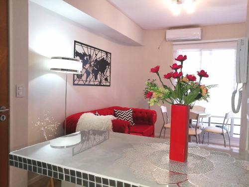 a living room with a red couch and a table with flowers at Movistar Arena "Rincón de ensueño" Palermo in Buenos Aires