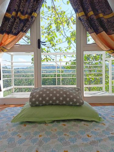 a bed in a room with a large window at JKO woodland resort in Malampay