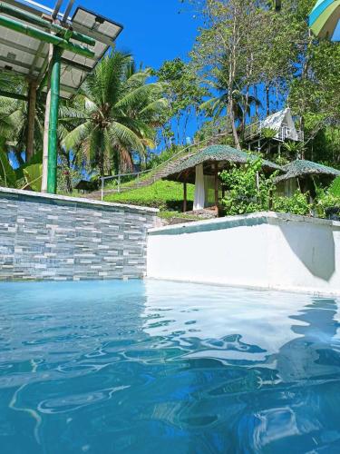 a pool of water in front of a house at JKO woodland resort in Malampay