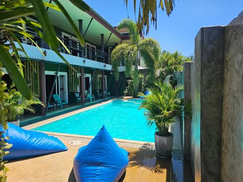a swimming pool with blue pillows in front of a house at Cha-Cha Hotel in Ko Lanta