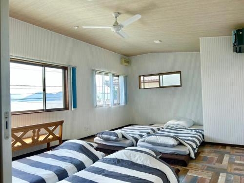 a row of beds in a room with windows at Beach Villa Tachibana in Onomichi