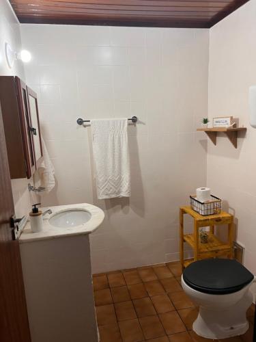 a white bathroom with a toilet and a sink at Casa da Lola in Angra dos Reis