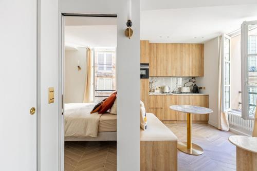 Cet appartement comprend une chambre et un salon avec un lit. dans l'établissement La Suite du Marais, à Paris